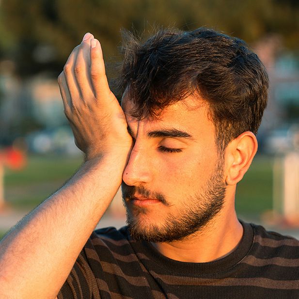 Man rubs eye with palm of his hand 
