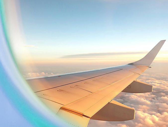 Airplane in a clear blue sky with clouds