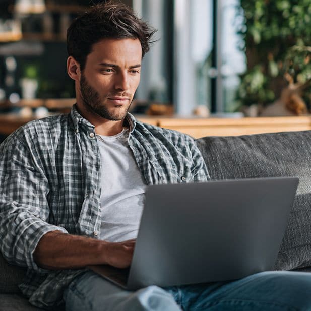 Lifestyle image: a young professional working on a computer, relaxed and comfortable, without glasses.