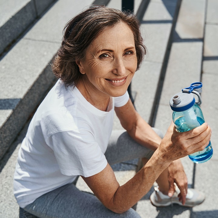 Older woman sitting on a step smiling